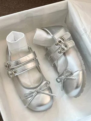 Silver metallic Mary Jane Lolita flats with buckle fastening and bow detail shown in overhead angled shoe box view with white liners
