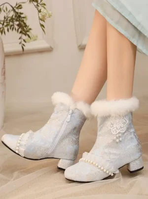 Side three-quarter angle view of sky blue Lolita ankle boots featuring side zipper closure, matching decorative details, and textured jacquard fabric with model wearing light green dress