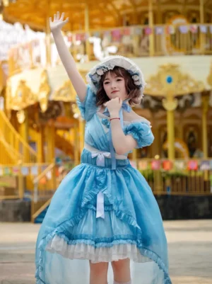 Sky blue lolita dress dynamic front view featuring off-shoulder sleeves, high-low asymmetrical hemline, and decorative waist bow during playful movement at amusement park