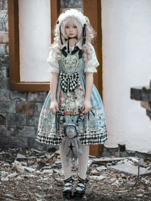 Sweet lolita jumper skirt in sky blue with Alice theme, front standing pose showing black bow chest decoration and whimsical cartoon patterns
