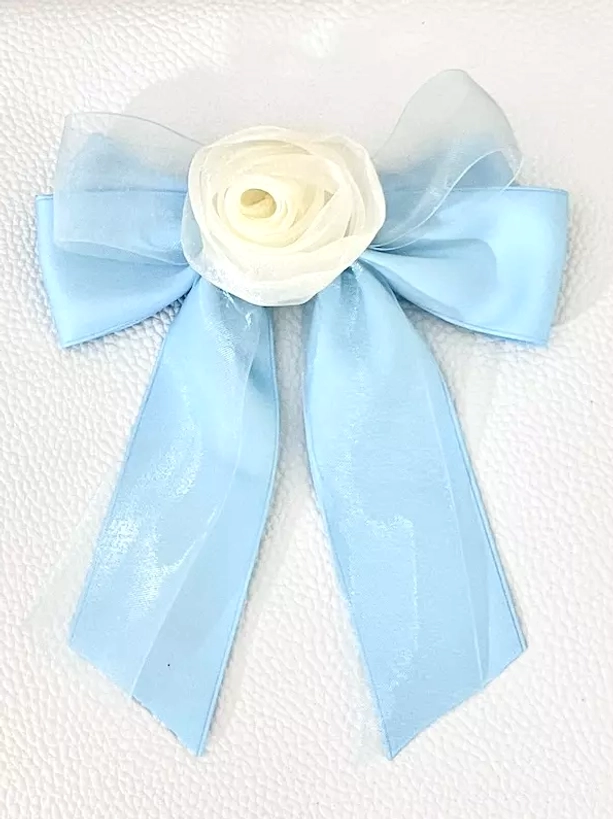 Sky blue sheer organza bow hair clip with cream rose embellishment, flat lay front view on white textured background, dreamy pastel sweet lolita accessory
