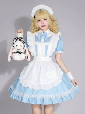 Sky blue sweet lolita maid dress front three-quarter view featuring white frilly apron with lace trim, blue bow tie, maid headband, and elegant silhouette worn by blonde model with rabbit plush bag