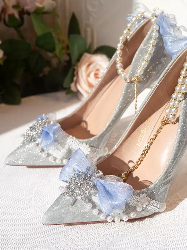 Overhead view of blue glitter bridal stiletto heels with snowflake crystal ornament pearl toe cap trims and pointed heel detail