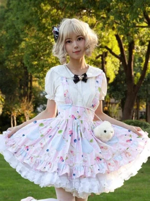 Soft pink floral lolita suspender skirt front three-quarter view outdoor lawn setting with ruffled hem and white blouse