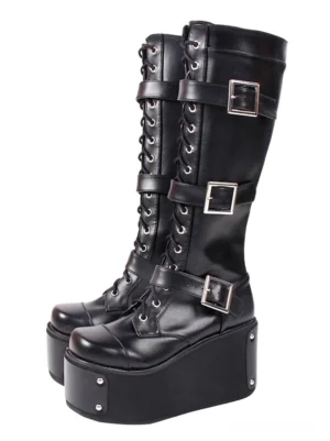 Black steampunk gothic knee-high platform boots with round toe front view showing lace-up design metal buckle straps and thick wedge sole with corner studs