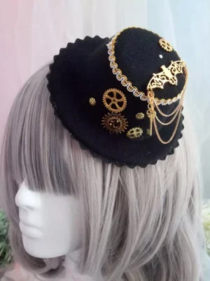 Steampunk Gothic Lolita mini top hat in black fabric with gold gears, bat motif, and decorative chain details, shown in left profile view on mannequin with silver grey wig
