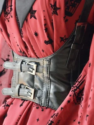 Black steampunk lolita corset belt oblique side angle showing shoulder strap buckle and double row metal buckles on red star-print dress