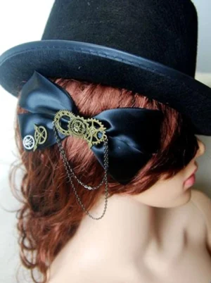 Steampunk lolita hair clip worn on mannequin with red curly hair and black top hat displaying back view and hanging chain decoration