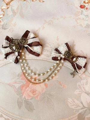 Steampunk lolita hair clips overhead flat lay view on vintage floral fabric showing dual-tone lace bows bronze metal ornaments pearl chain tassels and key charm pendant