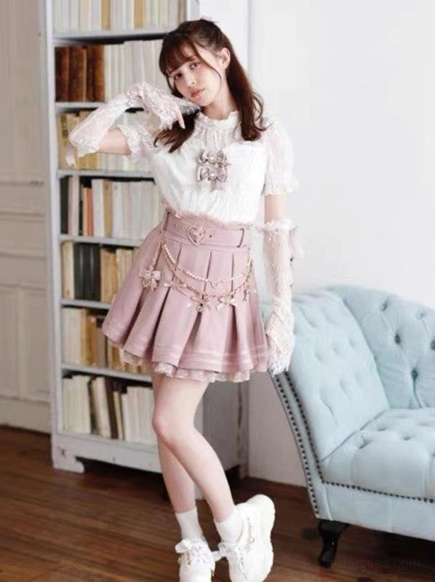 Pink steampunk gothic lolita coordinate with matching lace blouse, heart belt with chain trim, pleated skirt with ruffled lace underskirt, three-quarter body view