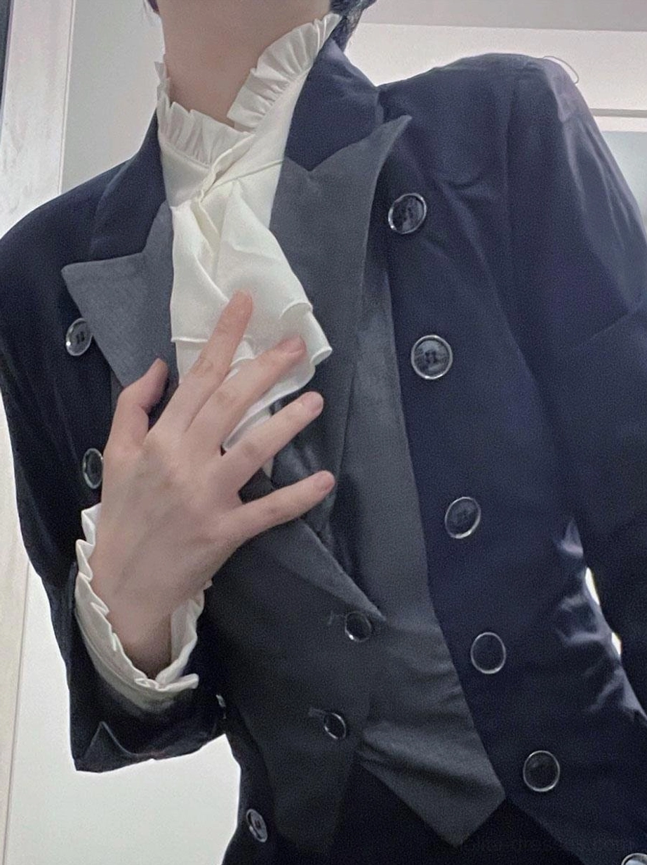 Close-up detail of steampunk Ouji Lolita overcoat showing layered lapels ruffled white neckwear cuffs round metal buttons craftsmanship