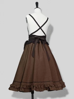 Steampunk Ouji Lolita suspender skirt rear view in coffee brown, displaying back cross-suspender design, waist bow sash, and layered ruffled hem with precision black trim work