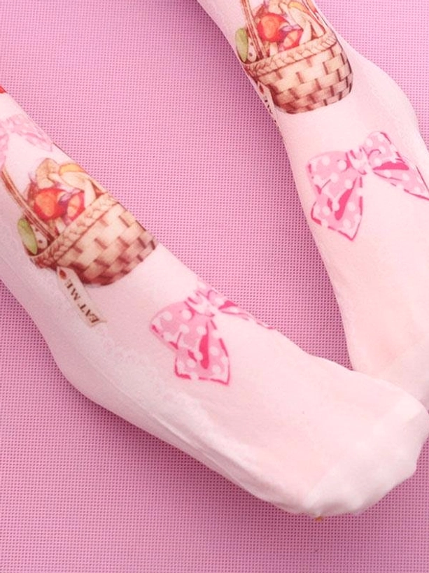 Close-up side view of strawberry basket pink velvet Lolita socks with polka dot bows and detailed strawberry basket print design on pink fabric