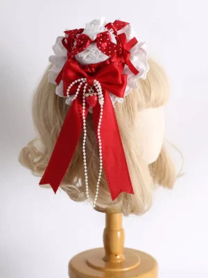 Sweet strawberry lolita hair clip with red satin bows and pearl tassels displayed on blonde mannequin wig, back view showing delicate lace trim and rococo design details
