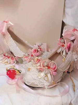 Sweet lolita strawberry themed heel shoes side profile view showing lace overlay pink floral bows dangling golden chains and red strawberry decoration
