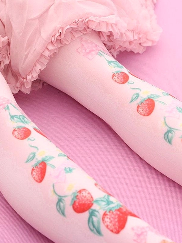 Lolita knee high strawberry vine socks worn on legs with pink ruffle skirt showing printed strawberries and vines on soft pink velvet base