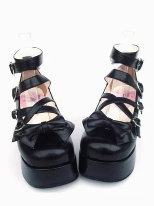 Sweet black matte lolita platform shoes with heart-shaped metal buckle straps and decorative front bow, displayed in front flat view on white background