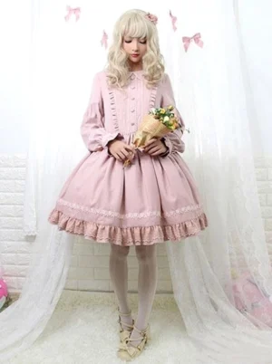 Dusty pink long-sleeve Lolita dress with lace-trimmed ruffled hem, front ruffle panel, and full-length sleeves on blonde model holding flower bouquet