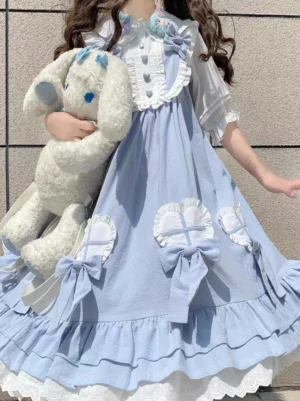 Light blue sweet lolita dress with white inner blouse model wearing curly brown hair holding plush rabbit showing ruffled collar and layered lace hem detail