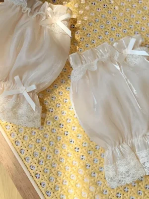 Light beige shiny organza puff oversleeves featuring decorative lace and white satin bows, showcasing lustrous fabric finish