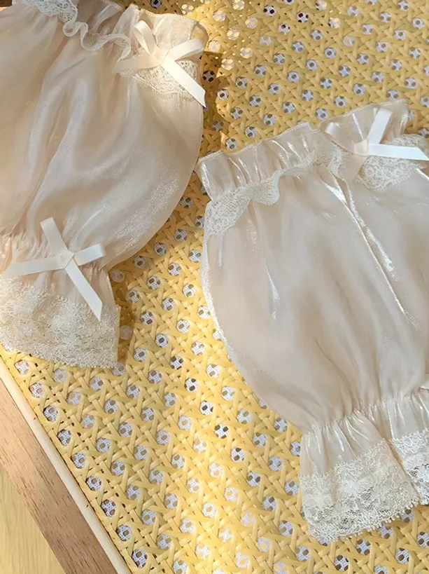 Light beige shiny organza puff oversleeves featuring decorative lace and white satin bows, showcasing lustrous fabric finish