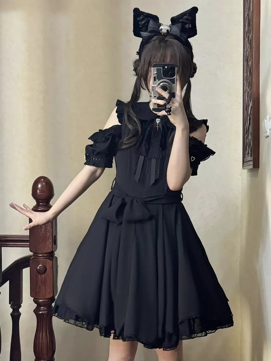 Black sweet lolita mini dress front three-quarter view on model indoor staircase setting with cold-shoulder puff sleeves bow headband lace-trimmed skirt hem detail