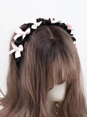 Sweet lolita black ruched satin bow headband with light pink bows rear left angle view on mannequin with brown long hair
