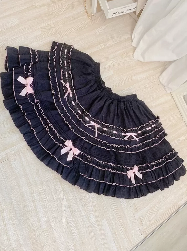 Black Sweet Lolita tiered ruffled skirt with white ruffled edges light pink bows layered hem flat lay overhead view