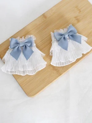 Sweet Lolita layered pleated lace oversleeves with blue satin bow embellishment, ruffled trim detail, wooden cutting board styling flat lay