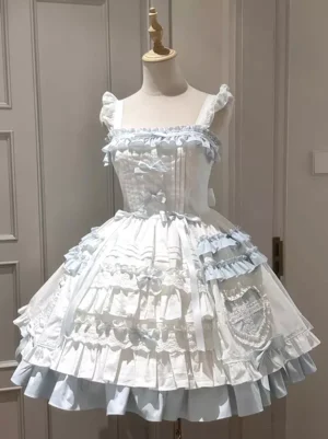 Sweet lolita spaghetti strap jumper dress with blue and white color scheme, detailed view of ruffled shoulder straps, embroidered lace pocket detail, corset-style bodice construction, and voluminous layered lace skirt silhouette