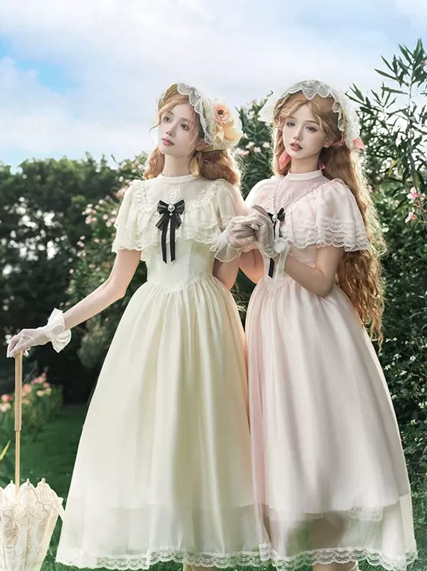 Full-body Lolita coordinate featuring vintage-inspired cream and pink dresses with matching bonnets, lace gloves, and garden outdoor styling