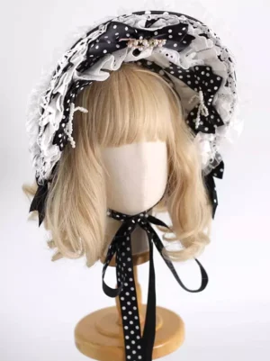 Lolita bonnet three-quarter angle showing metal brooch detail on main bow and extended polka dot chin straps on blonde wig mannequin