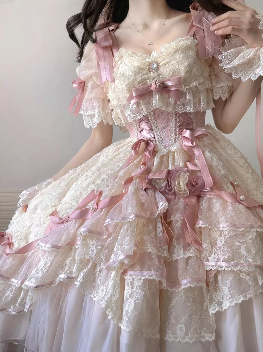 Close-up upper body detail of sweet lolita bridal dress highlighting corset bodice lace overlay and statement pink satin bows