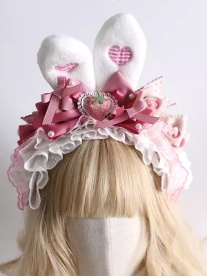 Sweet Lolita bunny ear headband with white plush ears and pink heart decals, frontal close-up view on blonde wig mannequin showing ruffled lace trim details