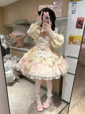 Full body front view of sweet cat print lolita dress with puffed long sleeves, layered ruffled hem, pink Mary Jane shoes, and frilled white socks