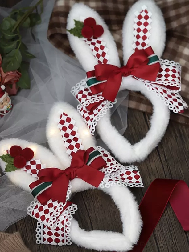 Two sweet lolita Christmas rabbit ear headbands displayed together on wooden and tulle background, festive holiday collection, one with illuminated LED bunny ears, matching plaid and holly embellishments