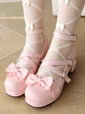 Pink Sweet Lolita chunky heel pumps with bow embellishment, front overhead view showing cross ankle straps and metal buckles, worn with pink sheer bow socks