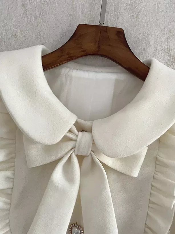 Lolita coat peter pan collar front close-up view hanging on wooden hanger showing embellished collar and ruffled shoulder panels