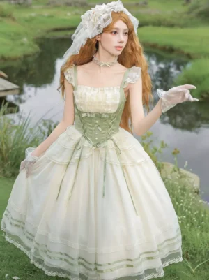 Sweet Lolita cottage gown front three-quarter view featuring cream-white base with sage green corset waist, lace-trimmed spaghetti straps, and tiered tulle skirt in outdoor riverside grassland setting
