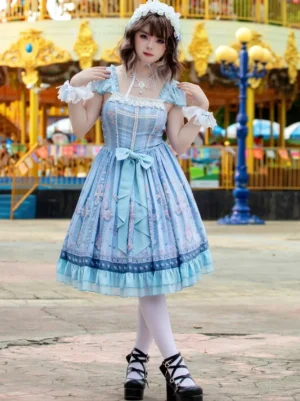 Sweet lolita JSK dress angled front view showcasing pleated A-line skirt, square lace neckline, wrist ruffled cuffs, and cross printed design details with carousel amusement park backdrop