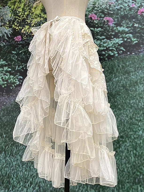 Sweet lolita sweep train tail asymmetrical high-low hem with ruffled tulle layers shown from rear garden setting
