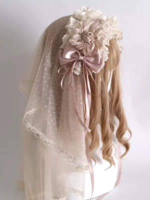 Sweet lolita dotted tulle floral hair veil with dusty pink satin bow and fabric flower accents, displayed on mannequin showing left front side view with lace trim details and delicate romantic aesthetic