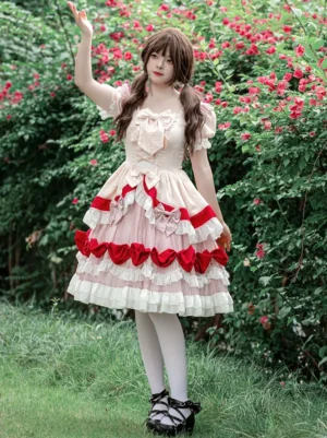 Sweet Lolita OP dress rear view showcasing layered ruffled skirt with red bow decorations and lace-up back design on model wearing white tights and black lolita shoes