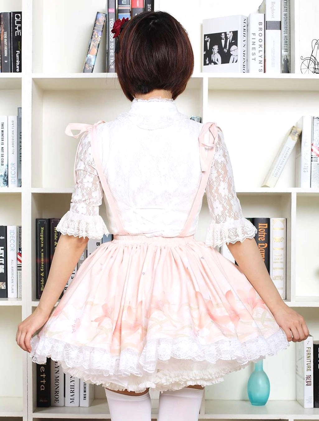 Back view of pink floral sweet lolita dress showing adjustable satin suspender straps and lace details