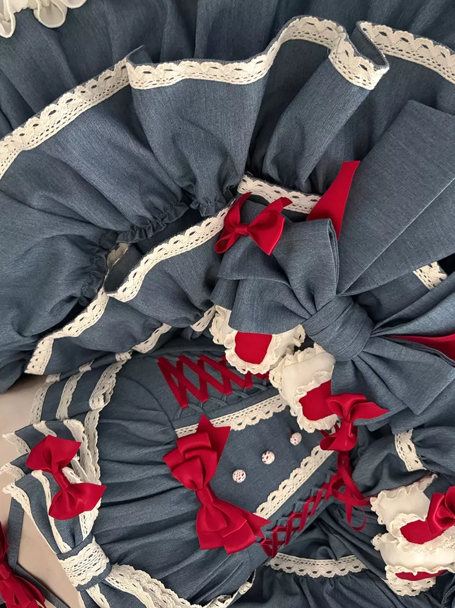 Side close-up detail shot of sweet lolita dress bodice showing ruffled edges red bow accents white lace and embroidered details