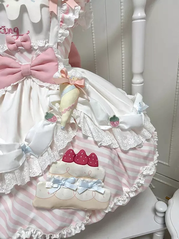 Close-up detail view of Sweet Lolita dress large pink bow strawberry embroidery cake-shaped applique and delicate lace frills