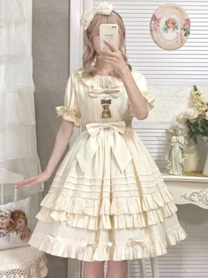 Jacquard sweet lolita dress featuring cream beige tone with multilayer ruffles, short sleeves, chest brooch decoration, and bow details - front eye-level pose