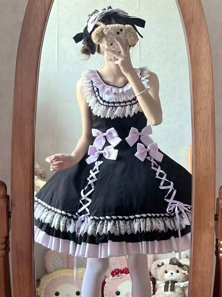 Sweet lolita dress on model from side angle showing lace-up construction details, sleeveless jumper dress with layered hem and decorative elements