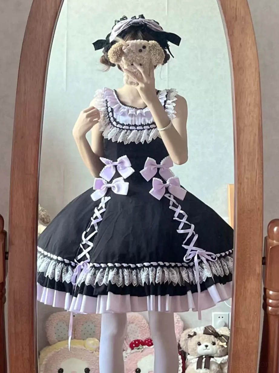 Sweet lolita sleeveless dress worn by model with matching hair accessory and plush toy, front mirror view showing lilac dress with side lace-up and layered ruffles
