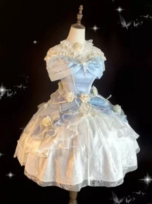 Front three-quarter angle view of sweet lolita princess dress displaying off-shoulder neckline, layered ruffled short skirt with dimensional floral decorations in blue-white color palette on dress form against dark starry background